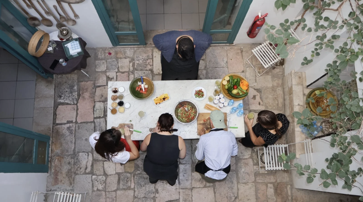Culinary workshop around a marble table in a traditional Tunisian courtyard at Dar Ben Gacem